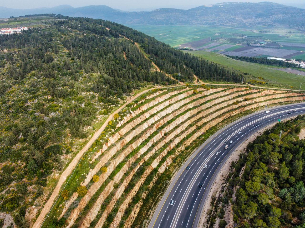 Vista aérea de rodovia com talude íngreme tratado — biomanta de coco